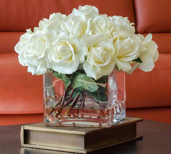 Hoa cắm bình thủy tinh thấp với hoa hồng trắng